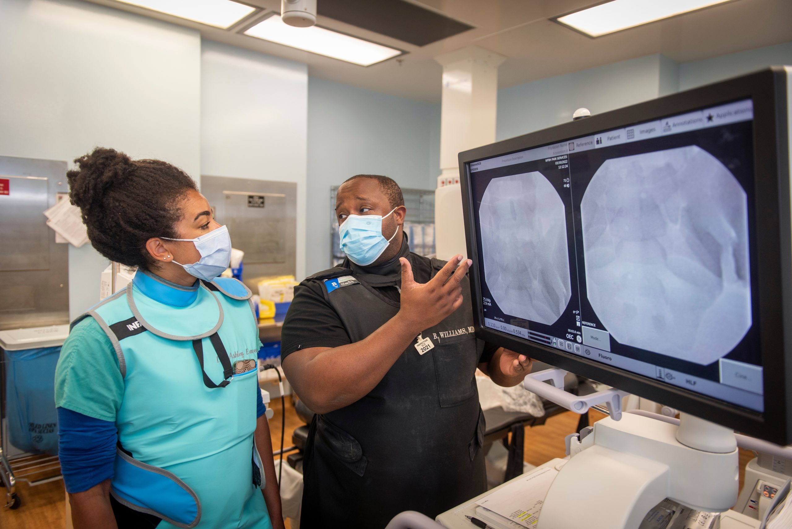 Brandon Leroy Williams, MD, works with resident Ashley Eaves, MD at the Pain Management Center on Brookstown.