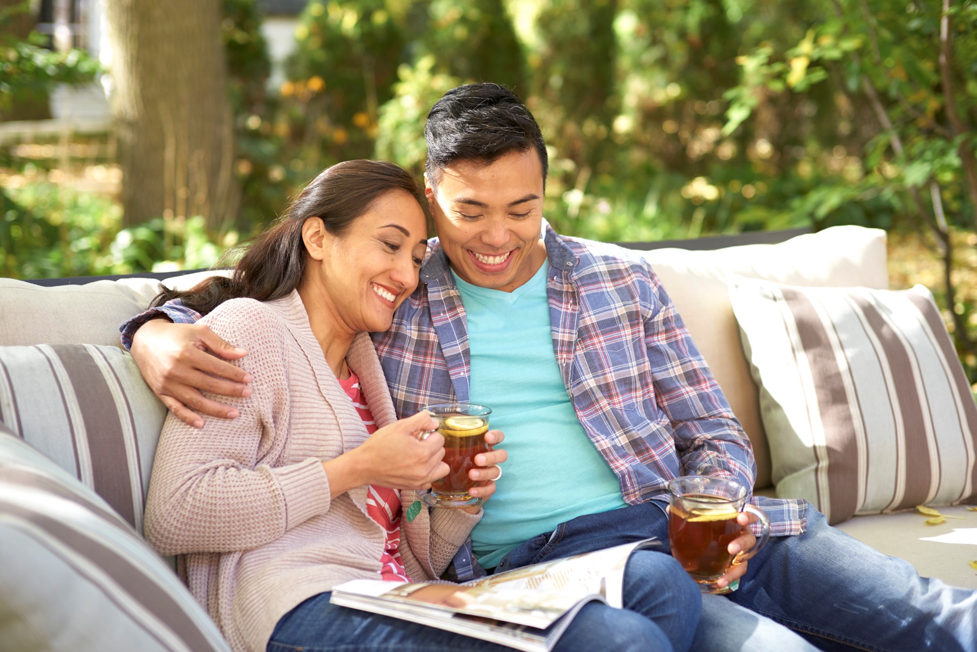 Couple drinking coffee on couch.
