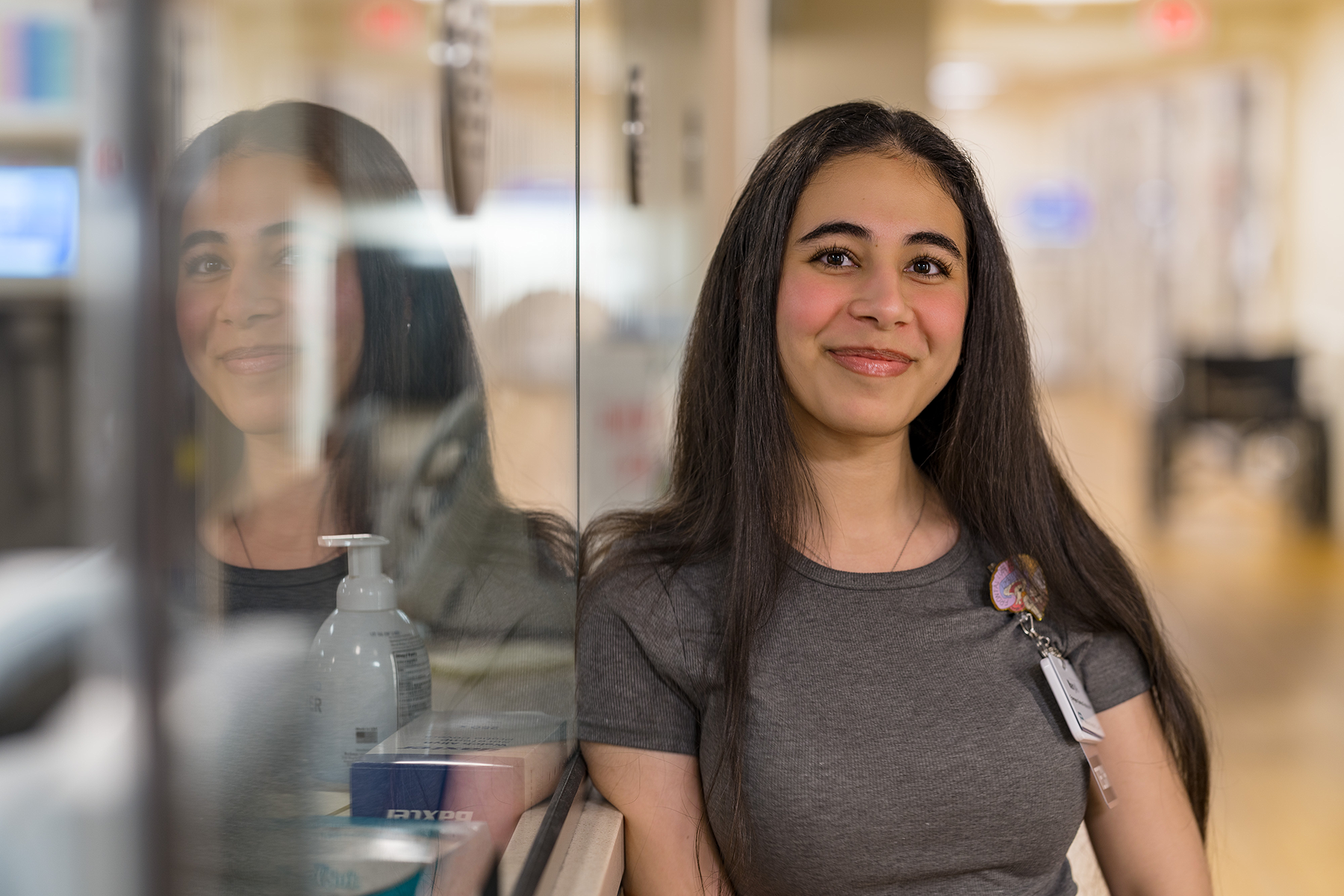 Female clinical staff member leaning up against check-in window