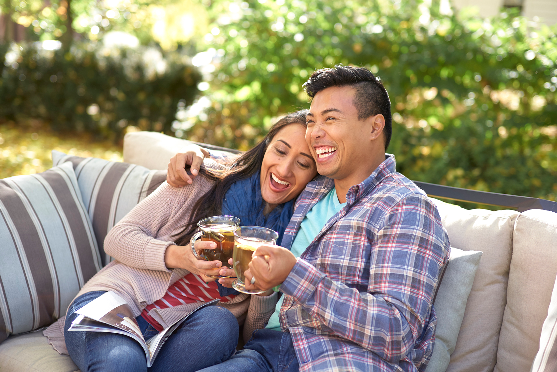 Couple sitting on patio together with cups of tea