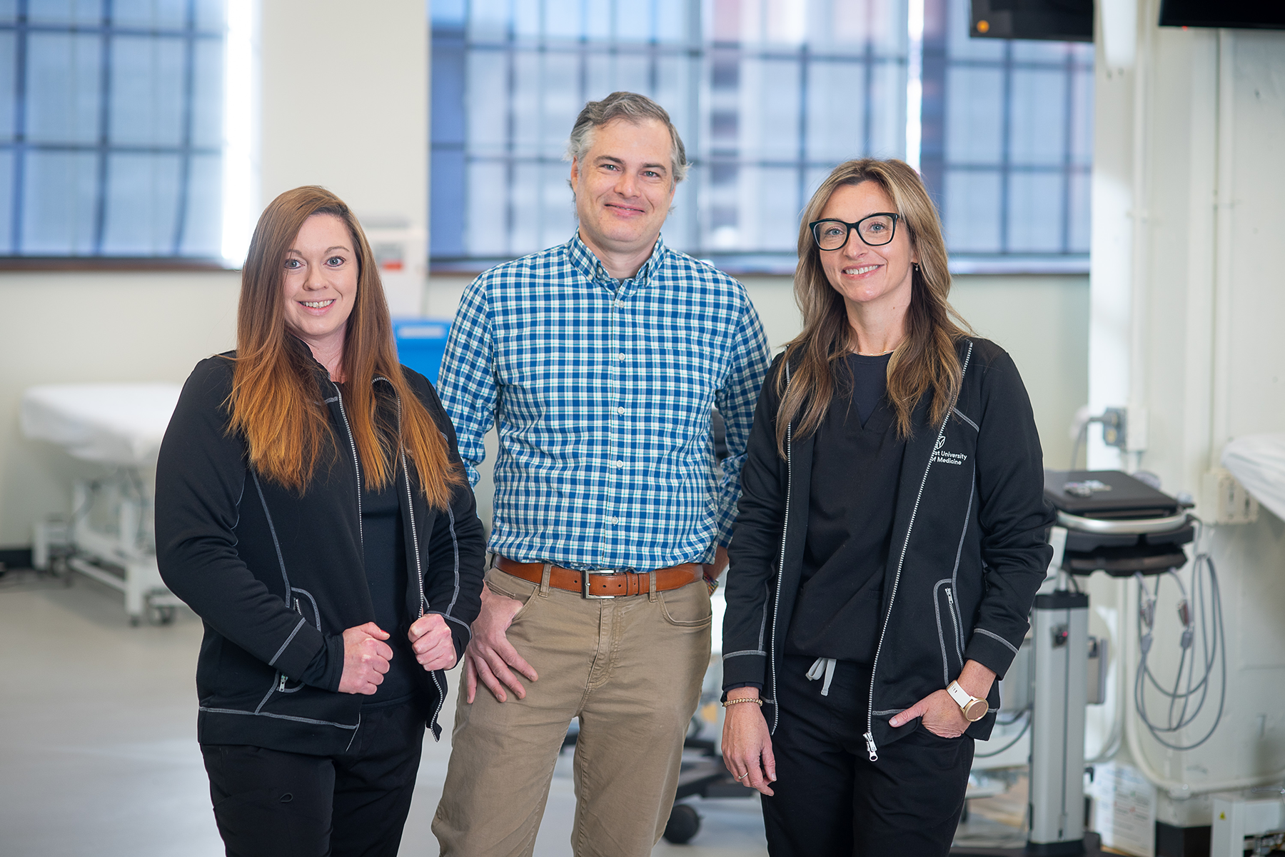 Group of three teammates standing in clinical setting
